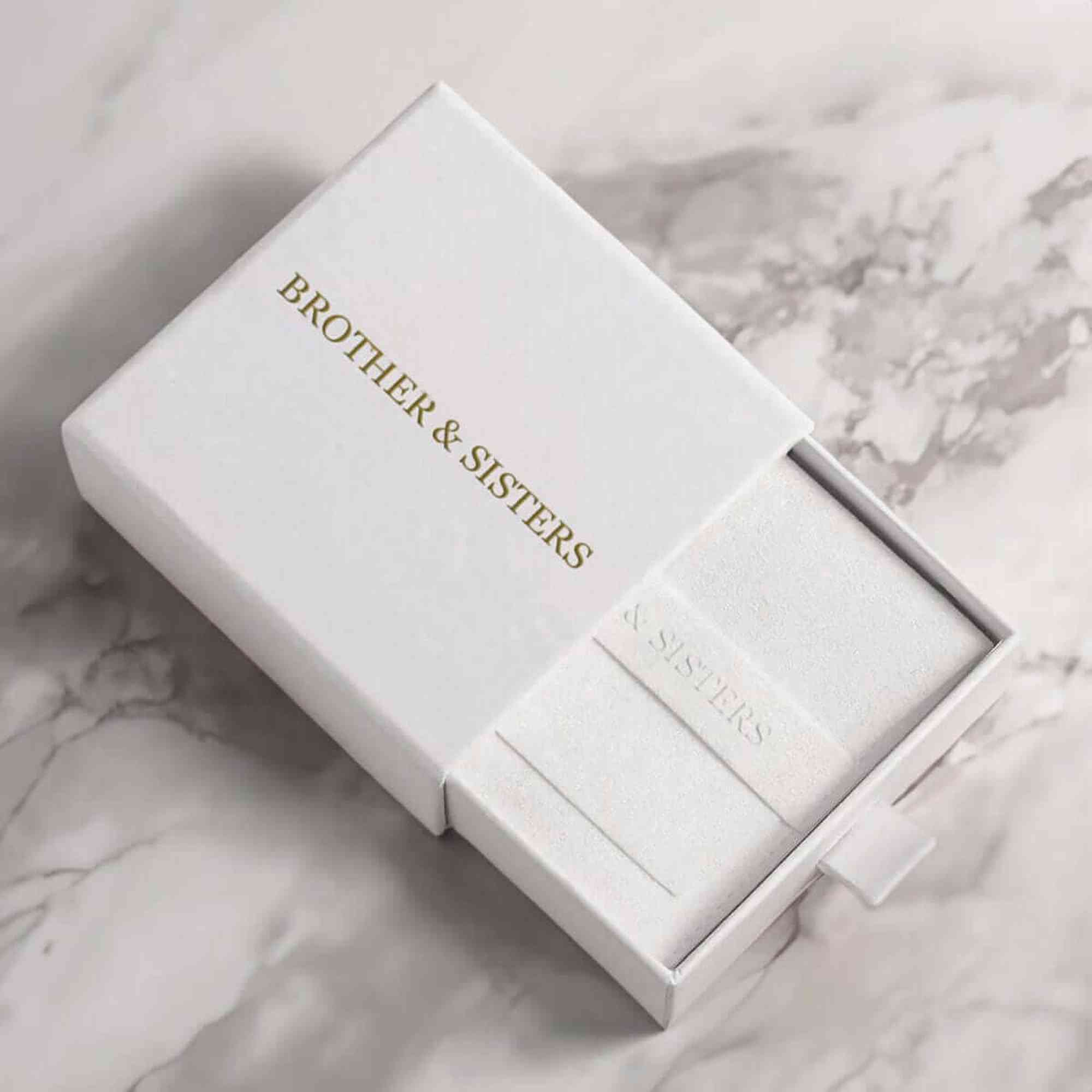 B&S Layla anklet inside white slide-drawer gift box with embossed suede pouch on marble — gift jewelry packaging