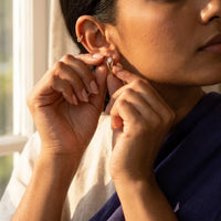 Thumbnail for Pear Crystal Huggie Hoops in Gold, being put on | SKU: 41007-gold