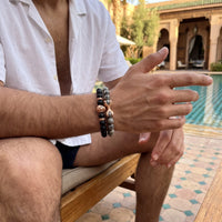 Thumbnail for Rose Gold Lion with Black & Grey Stones Set – worn by a man sitting | Brother & Sisters | SKU: 21369621-rose-gold-XS-14-15, 21369621-rose-gold-S-16-17, 21369621-rose-gold-M-18-19, 21369621-rose-gold-L-20-21, 21369621-rose-gold-XL-22-23