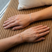 Thumbnail for Two wrists wearing the rose gold Crystal Bar Bracelet, seen from above on camel wool