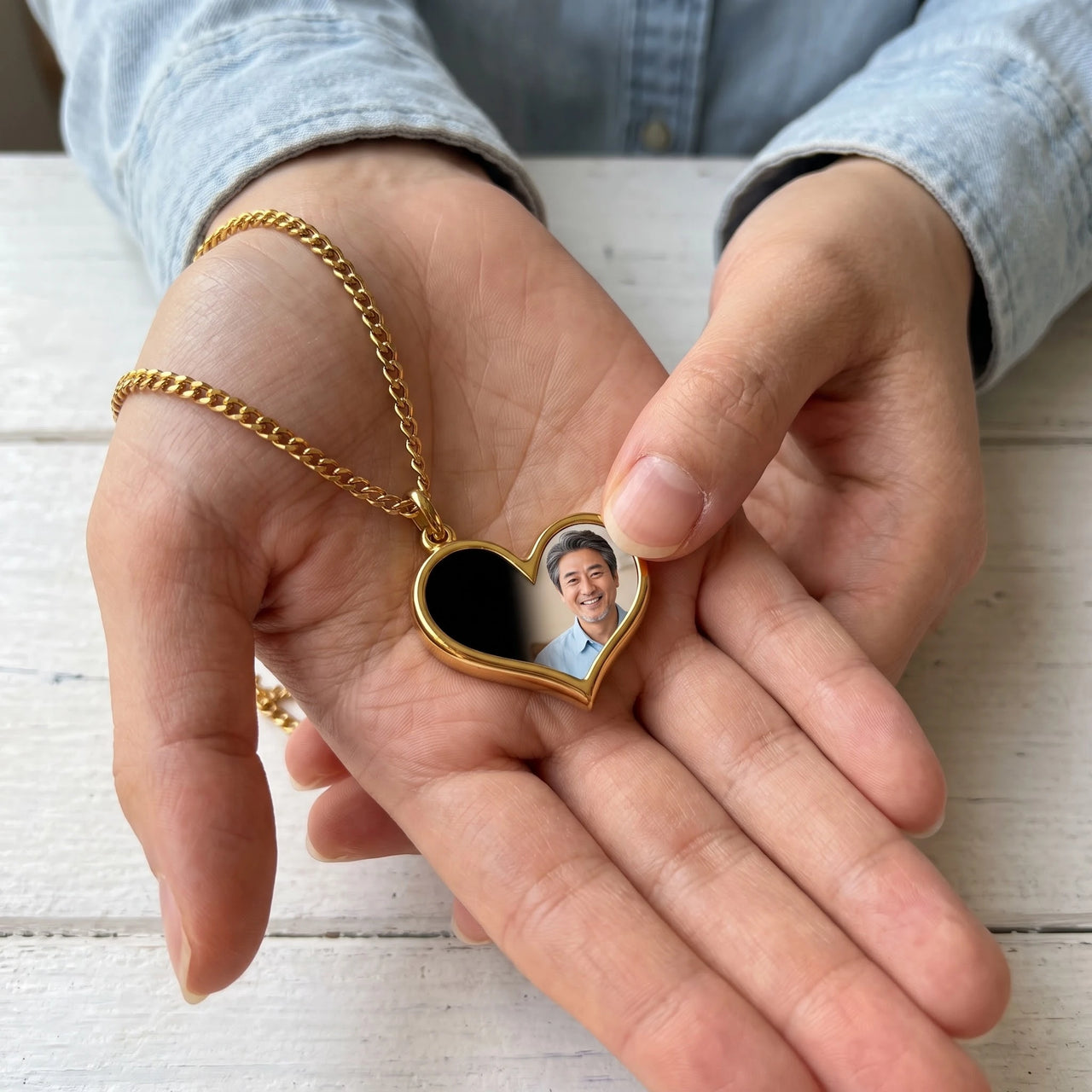 Thumb warming the gold heart pendant: the hidden photo appears under the thumb while the rest stays black | SKU: TPH-HRTN-GOLD